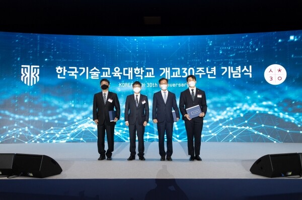 이성기 총장(오른쪽에서 두 번째)이 개교 30주년 기념식에서 30년사와 기념사진집을 헌정한 30년사 집필위원장, 총동문회장, 총학생회장과 기념촬영을 하고 있다. 사진=한국기술교육대 제공