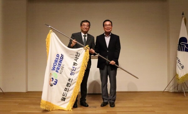 ‘38기 월드프렌즈 청년봉사단 해단식’에서 38기 전기석 단장(연세대학교 정경대학 경영학부 교수)이 대표로 유지상 회장에게 봉사단 기를 인계하고 있다. (사진: 광운대 제공)