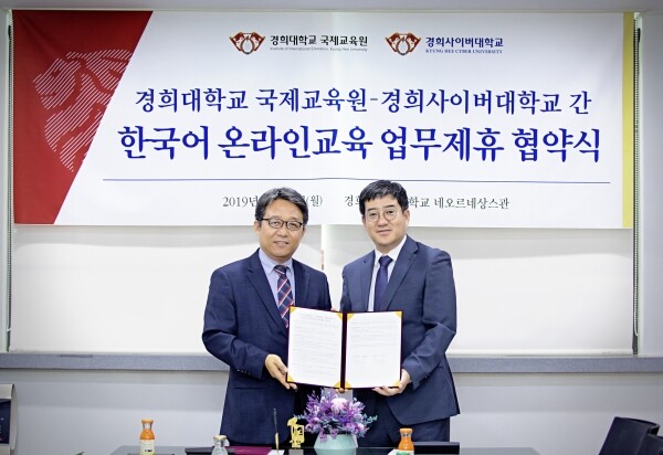 경희사이버대학교 김지형 총장 직무대행과 경희대학교 홍윤기 국제교육원장이 협약서를 들고 기념촬영 하고 있다. (사진: 경희사이버대 제공)