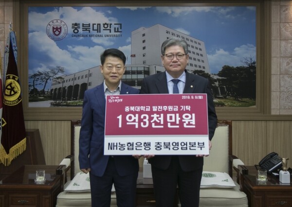 학교발전기금 1억 3천만원을 기탁한 NH농협 충북영업본부의 태용문 영업본부장(좌)이 김수갑 총장(우)과 기념촬영 하고 있다.