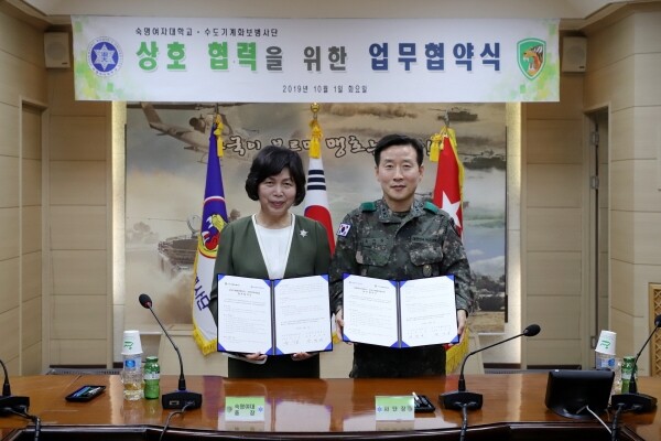 강정애 숙명여대 총장(좌)과 유기종 수도기계화보병사단 사단장(우)이 지난 1일 교육프로그램 및 인적자원 상호교류에 관한 협약을 체결한 뒤 기념사진을 찍고 있다. (사진: 숙명여대 제공)