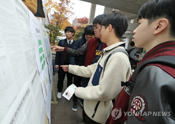 13일 수능 예비소집일에 참석한 수험생들이 배치도 및 유의사항을 살펴보고 있다 (사진: 연합뉴스)