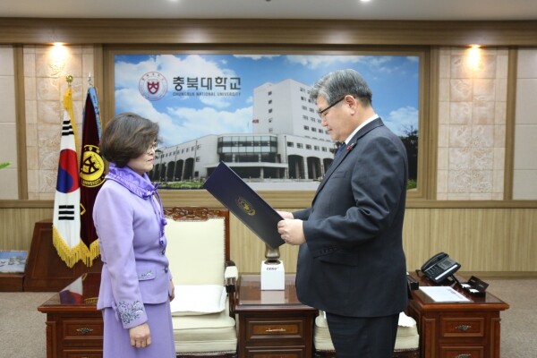 김수갑 총장(오른쪽)이 김성은 사서사무관에게 훈장을 전수하고 있다