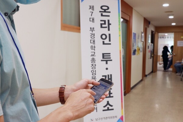 15일 오전 부경대학교 대학본부 7층에 마련된 제7대 부경대학교총장임용후보자선거 온라인 투·개표소 앞에서 한 선거인이 모바일을 이용해 투표하고 있다