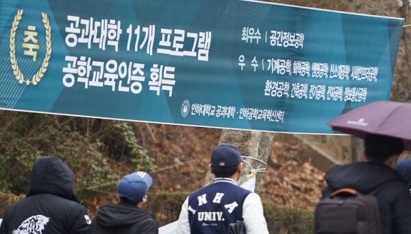인하대 교정에 걸린 '공과대학 11개 프로그램 공학교육인증 획득' 축하 현수막 앞으로 학생들이 걸어가고 있다. 사진=인하대 제공