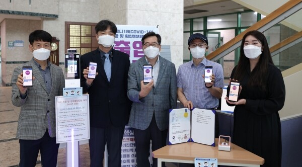 코로나19자가진단앱을 보여주고 있는 인제대 교직원