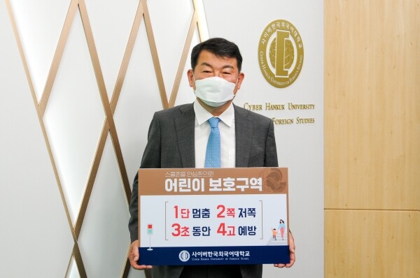 김중렬 사이버한국외대 총장이 ‘1단 멈춤! 2쪽 저쪽! 3초 동안! 4고 예방!’이라는 어린이 교통안전 표어가 담긴 패널을 들고 ‘어린이 교통안전 챌린지’에 참여했다. 사진=사이버한국외대 제공