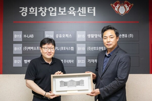 (왼쪽부터) 발전기금 전달식을 진행 중인 김봉석 창업보육센터장과 한의과대학 장문석 교수(큐제니틱스 대표). 사진=경희대 창업보육센터 제공