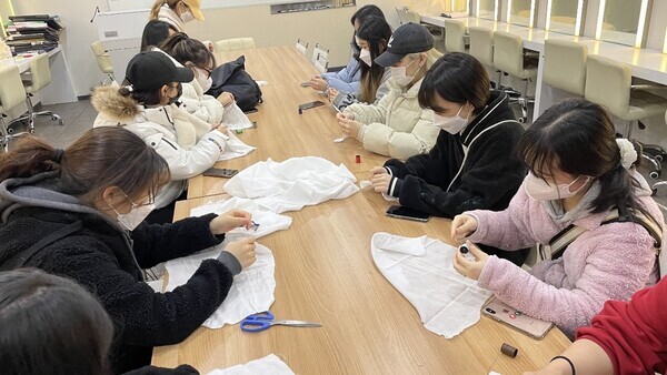 삼육보건대 뷰티융합과 의료미용전공 1학년 학생들이 미혼모 아이들에게 전달할 가재 수건을 만들고 있다. 사진=삼육보건대 제공