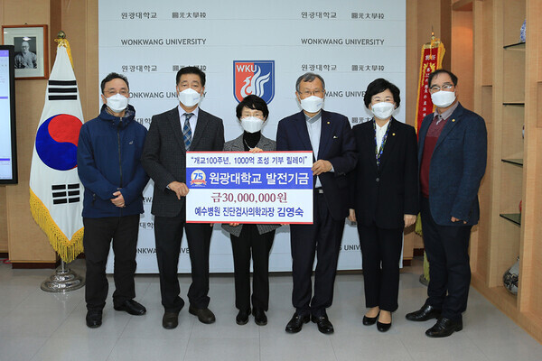 원광대 학부모 김영숙(왼쪽에서 세번째)씨가 대학 발전기금 3천만원을 기부한 후 박맹수(〃네번째) 총장 등 대학 관계자들과 기부금 기탁 증서를 들어보이고 있다. 사진=원광대 제공