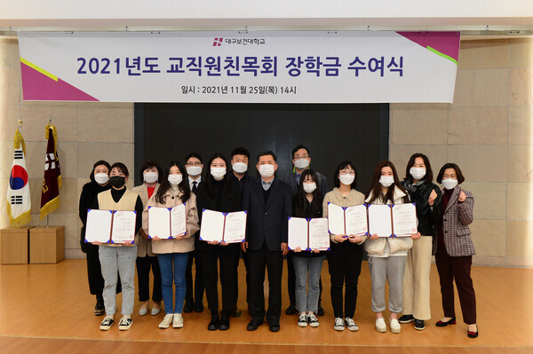 대구보건대 교직원 친목회 관계자와 장학금을 받은 학생들이 지난 25일 장학금 수여식이 끝난 뒤 기념촬영 하고 있다. 사진=대구보건대 제공