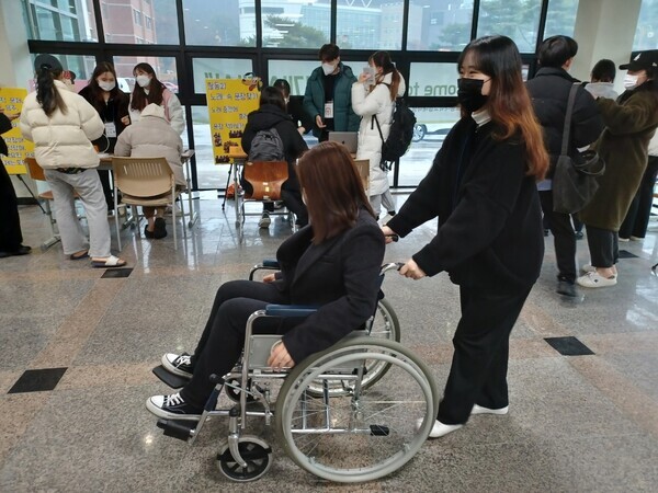 한국교통대가 지난 30일 마련한 '2021년 장애인식 개선 행사'에 참여한 학생이 휠체어를 타고 장애를 체험하고 있다. 사진=한국교통대 제공
