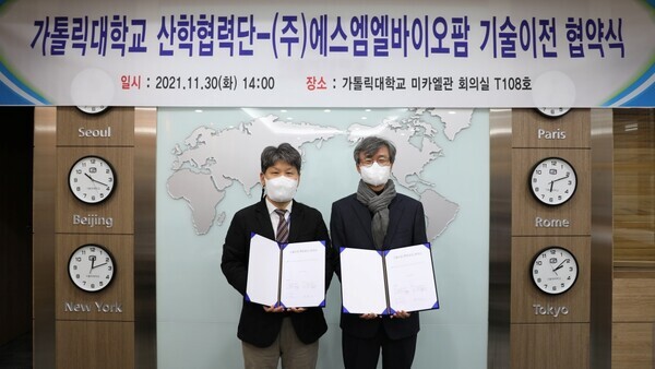 나 건(왼쪽) 가톨릭대 산학협력단과 남재환 SML바이오팜 대표가 백신 기술 이전 협약을 체결하고 협약서를 펼쳐보이고 있다. 사진=가톨릭대 제공