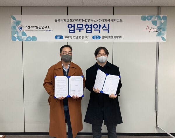  김기영(왼쪽) 페어코드 대표와 박종혁 충북대 보건과학융합연구소 단장이 23일 협약서를 들고 기념촬영을 하고 있다. 사진=충북대 제공