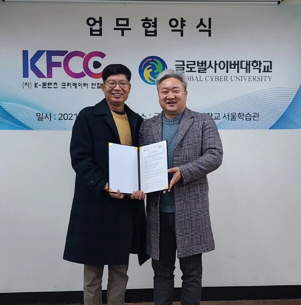 송재룡(왼쪽) K-콘텐츠크리에이터연합회 회장과 천범주 글로벌사이버대 방송연예학과 학과장이 업무협약 체결 후 업무협약서를 펼쳐보이고 있다. 사진=글로벌사이버대 제공