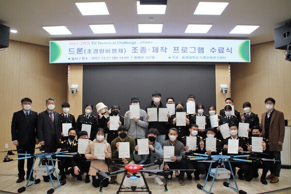 지난 21일 동명대 드론 조종·제작 프로그램 수료식에 참가한 학생들이 드론과 수료증을 들고 기념촬영을 하고 있다. 사진=동명대 제공