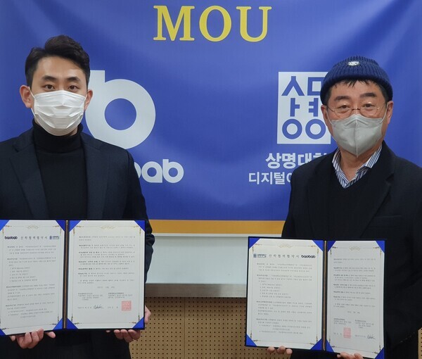 양종훈(오른쪽) 상명대 디지털이미지연구소장과 최진범 바오밥파트너즈 대표가 지난 29일 업무협약을 체결한 뒤 협약서를 펼쳐보이고 있다. 사진=상명대 제공