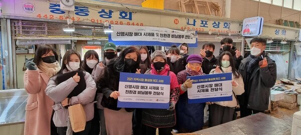 군산대 LINC+사업단 사회혁신산학협력센터 관계자들과 학생들이 신영시장 수산물매대 시제품 전달식에서 상인들과 기념촬영을 하고 있다. 사진=군산대 제공
