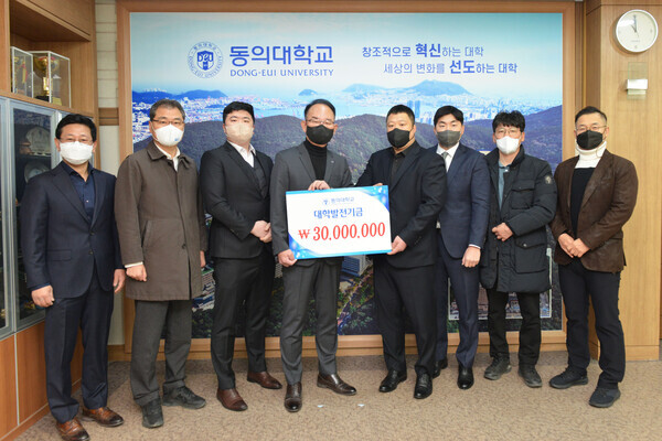 한수환(왼쪽에서 네 번째) 동의대 총장과 관계자들이 유도부 졸업생 대학발전기금 전달식에서 기탁증서를 들어보이고 있다. 사진=동의대 제공