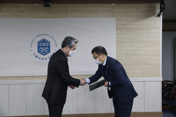 김덕현(왼쪽) 가톨릭관동대 총장이 ‘2021학년도 연구업적 우수 교원 시상식’에서 우수 교원에게 상장을 전달하고 있다. 사진=가톨릭관동대 제공