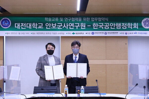 엄정호(왼쪽) 대전대 안보군사연구원장과 정세종 한국공안행정학회장이 업무협약을 체결하고 협약서를 펼쳐보이고 있다. 사진=대전대 제공