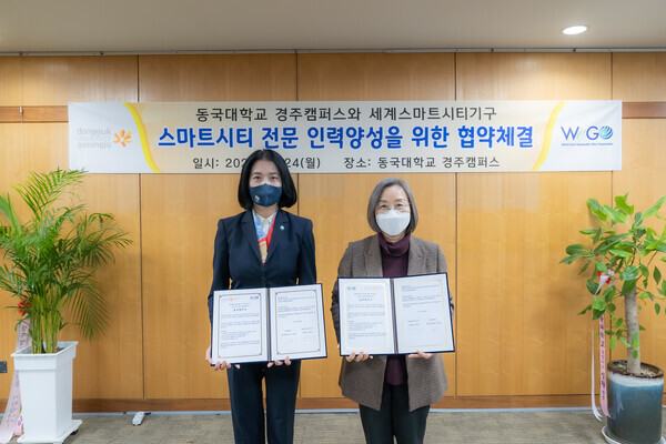 이영경(오른쪽) 동국대 경주캠퍼스 총장과 박정숙 세계스마트시티기구 사무총장이 24일 스마트시티 전문 인력 양성을 위한 업무협약을 체결하고 협약서를 펼쳐보이고 있다. 사진=동국대 경주캠퍼스 제공