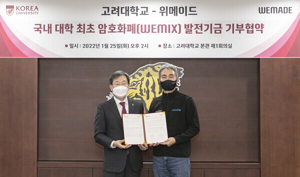 정진택(왼쪽) 고려대 총장과 장현국 위메이드 대표가 암호화폐 위믹스 발전기금 기부협약식에서 협약서를 펼쳐보이고 있다. 사진=고려대 제공