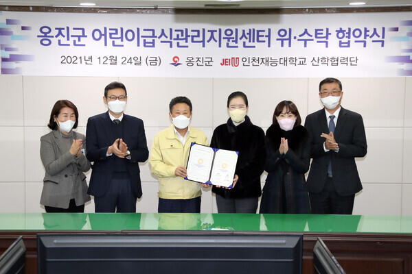 인천재능대와 인천광역시 옹진군 관계자들이 지난해 12월 24일 어린이급식관리지원센터 위·수탁을 위한 협약을 체결하고 협약서를 들어보이고 있다. 사진=옹진군 제공