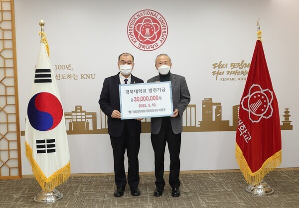 이철우(오른쪽) 경북대 교수가 10일 진행된 발전기금 전달식에서 홍원화 경북대 총장에게 발전기금을 전달한 뒤 함께 기탁증서를 들어보이고 있다. 사진=경북대 제공