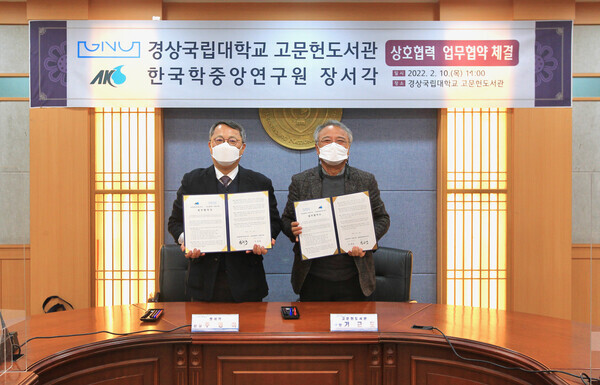 주영하(왼쪽) 한국학중앙연구원 장서각 관장과 기근도 경상국립대 고문헌 도서관장이 업무협약을 체결하고 협약서를 펼쳐보이고 있다. 사진=경상국립대 제공