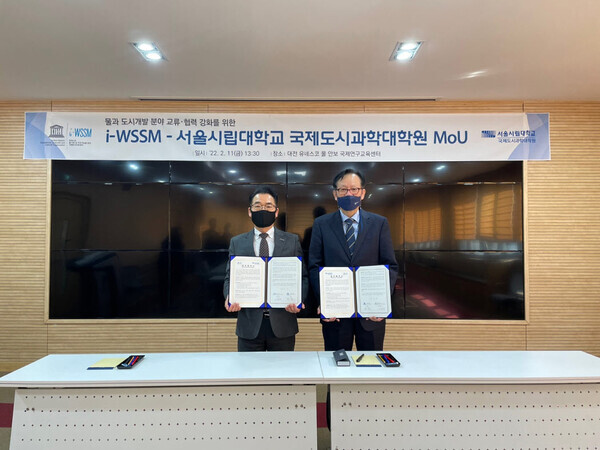 박 현(오른쪽) 서울시립대 국제도시과학대학원장과 신봉우 유네스코 물안보 국제연구교육센터장이 업무협약을 체결한 뒤 협약서를 펼쳐보이고 있다. 사진=서울시립대 제공