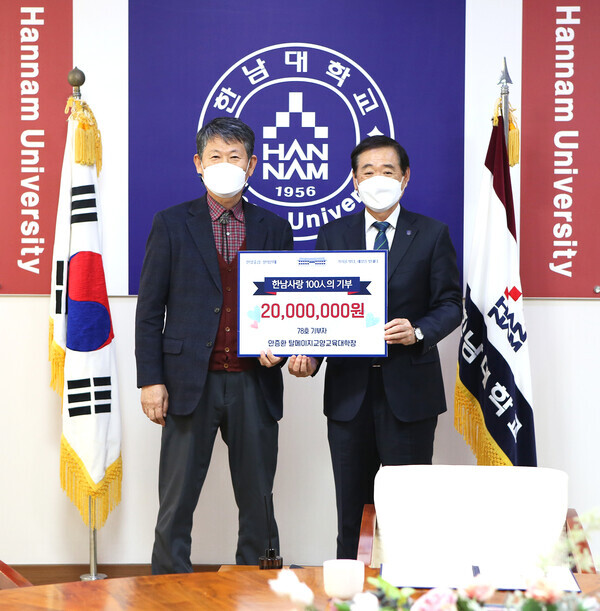 안증환(왼쪽)  탈메이지교양교육대학장이 이광섭 총장에게 발전기금을 전달한 후 기념촬영하고 있다. 사진=한남대 제공