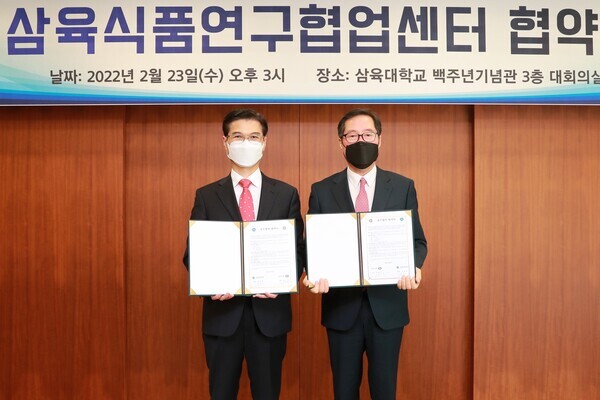 김일목(왼쪽) 삼육대 총장과 전광진 삼육식품 사장이 업무협약을 체결하고 협약서를 펼쳐보이고 있다. 사진=삼육대 제공