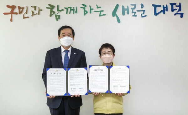 이광섭(왼쪽) 한남대 총장과 박정현 대덕구청장이 업무협약을 체결하고 협약서를 펼쳐보이고 있다. 사진=한남대 제공