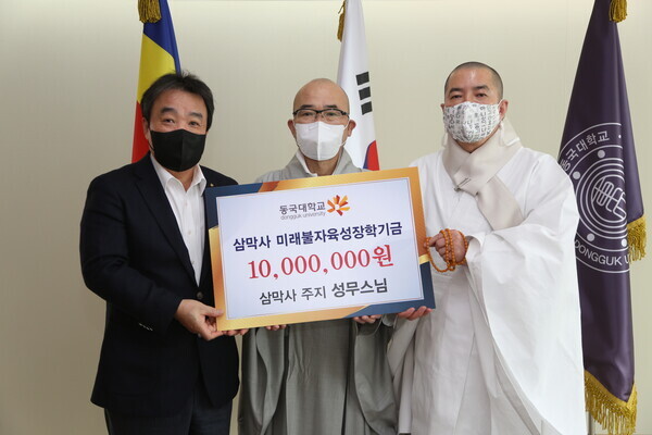 (왼쪽부터)윤성이 동국대 총장, 삼막사 주지 성무스님, 건학위원장 돈관스님이 장학기금증서를 들고 기념촬영을 하고 있다. 사진=동국대 제공