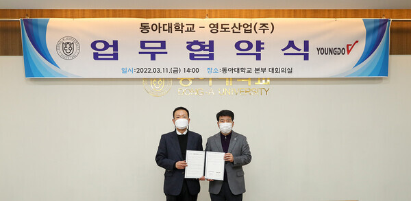 이해우(오른쪽) 동아대 총장과 이광호 영도산업 회장이 업무협약을 체결하고 협약서를 펼쳐보이고 있다. 사진=동아대 제공