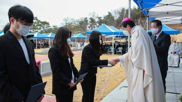 조환길(오른쪽) 천주교 대구대교구장이 이문희 대주교 장학금 선발 학생들에게 장학증서를 수여하고 있다. 사진=대구가톨릭대 제공