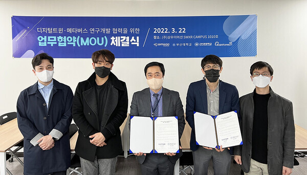 김대희(가운데) 삼우이머션 대표와 배혜림(왼쪽에서 네 번째) 부산대 산업공학과 교수가 업무협약식에서 협약서를 펼쳐보이고 있다. 사진=부산대 제공