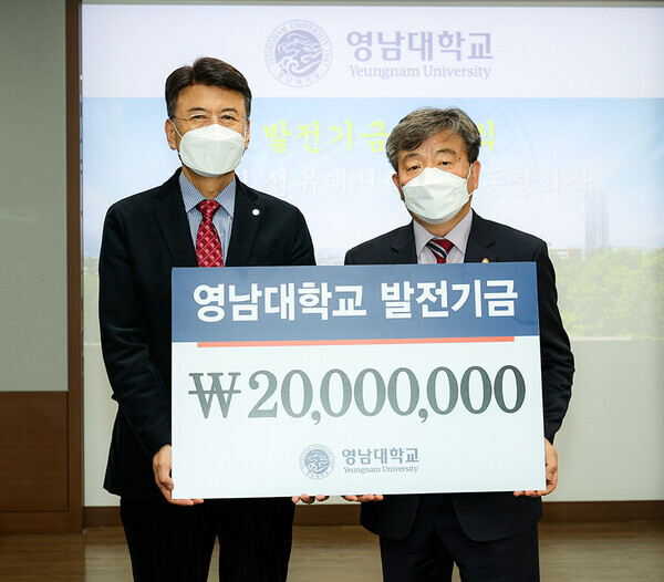 김이진(오른쪽) 영남대 섬유패션학부 총동창회장과 최외출 총장이 대학발전기금 전달식에서 기탁증서를 들어보이고 있다. 사진=영남대 제공