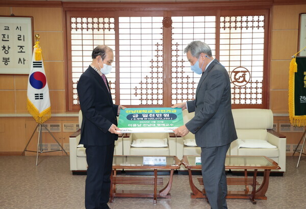 이용남(왼쪽) 전남대 명예교수가 정성택 총장에게 대학 발전기금을 전달하고 있다. 사진=전남대 제공