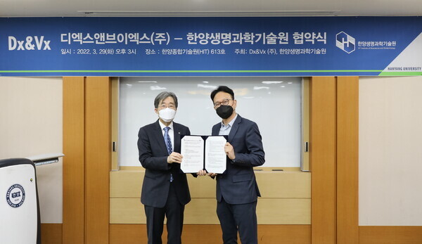 박상태(오른쪽) 디엑스앤브이엑스 대표와 배상철 한양대 생명과학기술원장이 업무협약식에서 협약서를 펼쳐보이고 있다. 사진=한양대 제공