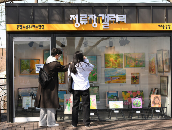 순천향대가 마련한 ‘제13회 행복한 그림회 정기전’에 전시된 작품을 지나가던 시민들이 감상하고 있다. 사진=순천향대 제공