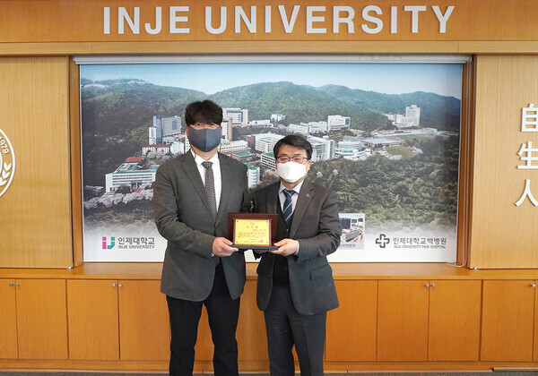 인제대 졸업생 김남균(왼쪽) 씨와 전민현 총장이 감사패를 들어보이고 있다. 사진=인제대 제공