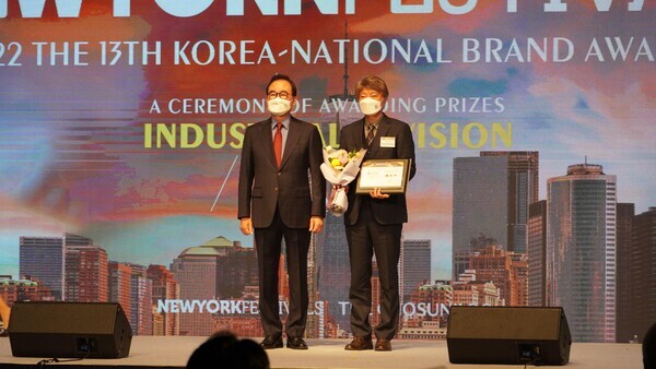 한명석(오른쪽) 아주자동차대 입학처장이 지난 6일 2022 대한민국 국가브랜드 대상 시상식에서  상장과 꽃다발을 들고 국가브랜드대상 수상을 자축하고 있다. 사진=아주자동차대 제공