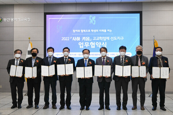 한국해양대와 부산시교육청, 부산 사하구, 부산지역 대학 관계자들이 '2022 사하 키움 고교학점제 선도지구’ 업무협약식에서 협약서를 펼쳐보이고 있다. 사진=한국해양대 제공