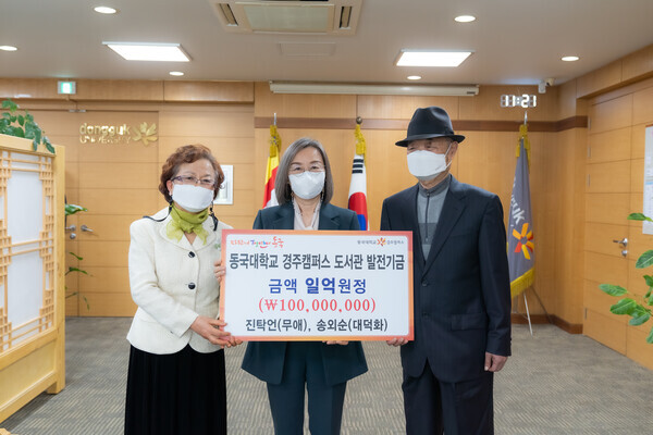 진탁언(오른쪽)·송외순(왼쪽) 부부가 이영경 동국대 경주캠퍼스 총장에게 도서관 발전기금을 전달한 후 기념촬영하고 있다. 사진=동국대 경주캠퍼스 제공