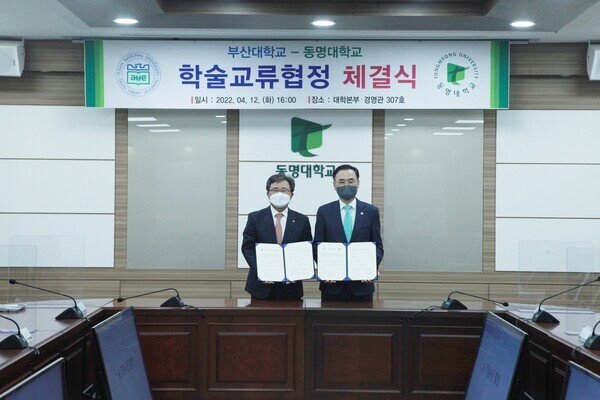 전호환(왼쪽) 동명대 총장과 차정인 부산대 총장이 학술교류 협정을 체결한 후 협약서를 펼쳐보이고 있다. 사진=동명대 제공