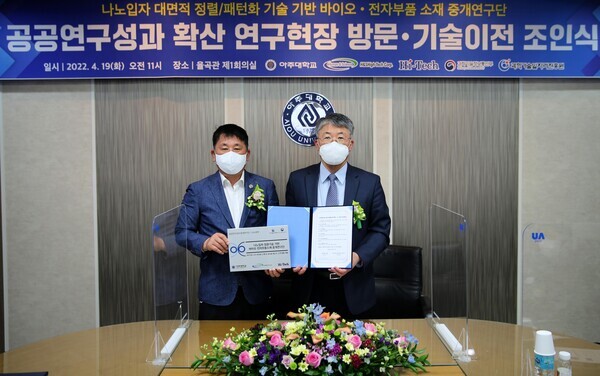 최기주(오른쪽) 아주대 총장과 기술이전을 받은 김정희 에이치엔에스하이텍 대표가 기술이전 조인식에서 기념촬영을 하고 있다. 사진=아주대 제공