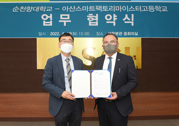 유성용(오른쪽) 순천향대 창의라이프대학장과 조동헌 아산스마트팩토리마이스터고 교장이 업무협약을 맺은 휘 협약서를 펼쳐보이고 있다. 사진=순천향대 제공