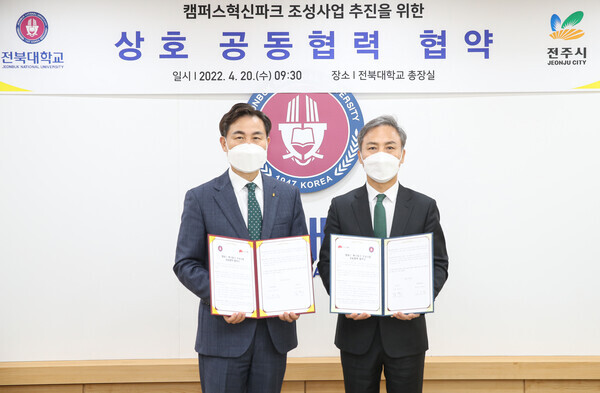 김동원(왼쪽) 전북대 총장과 김승수 전주시장이 업무협약 체결 후 협약서를 펼쳐보이고 있다. 사진=전북대 제공